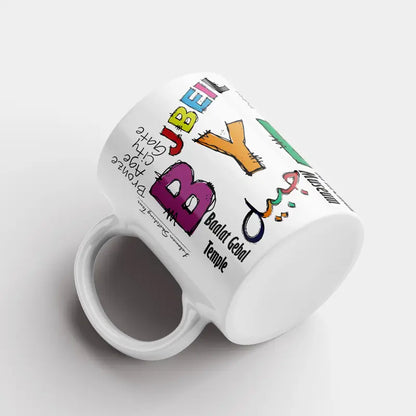 White mug with colorful text and graphics on a white background