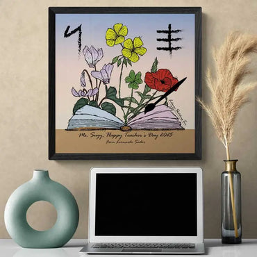 Teacher's Day gift ide poster with an open book with a paint brush and on the background Lebanese flowers that bloom around teacher's day date as well and their initials written in Phoenician letters