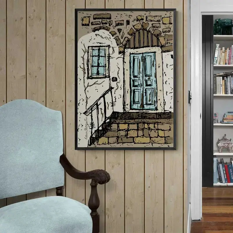 Framed artwork of a Lebanese sandstone house, with blue door and window next to a chair. Lebanese poster in portrait format